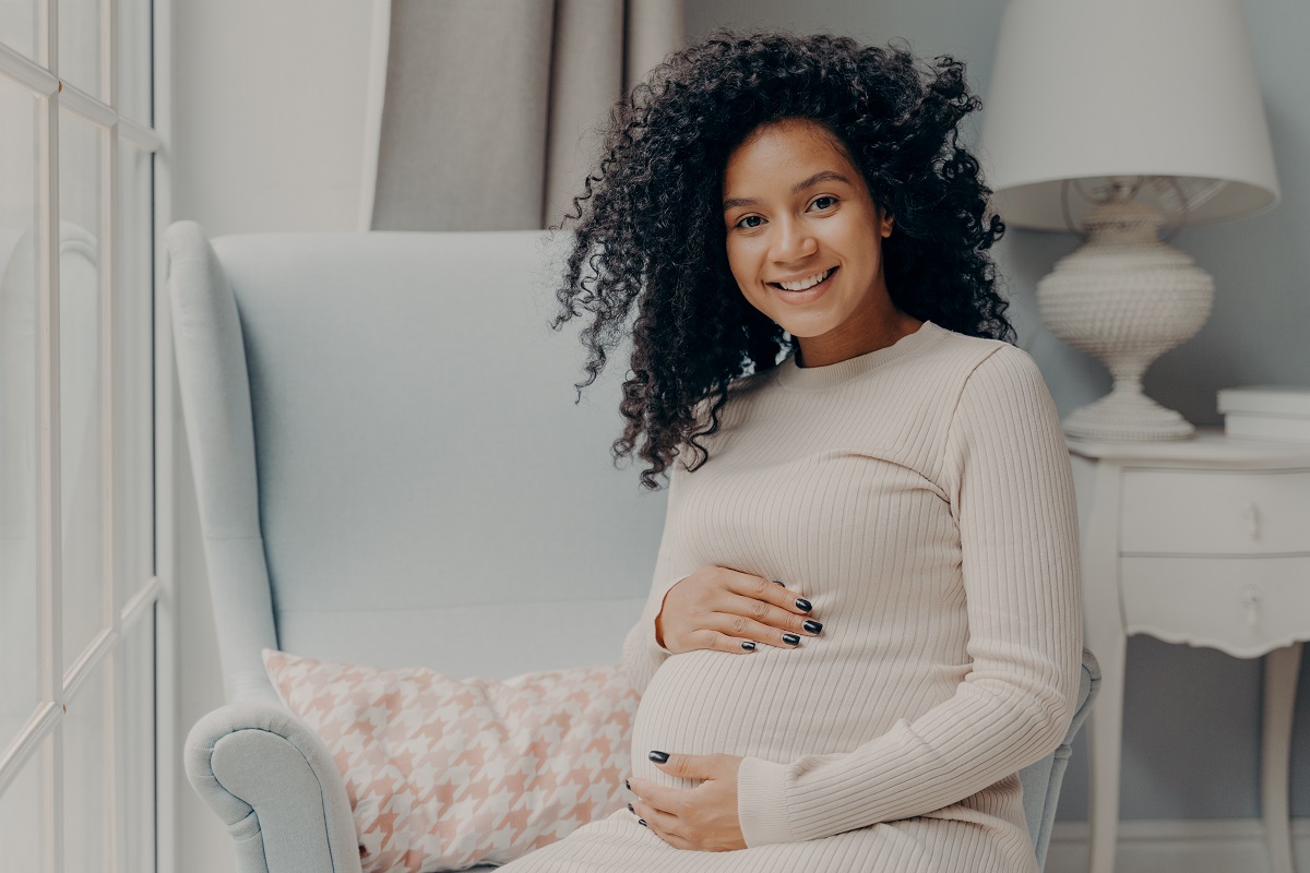 beautiful pregnant african woman enjoying pregnancy, spending time at home