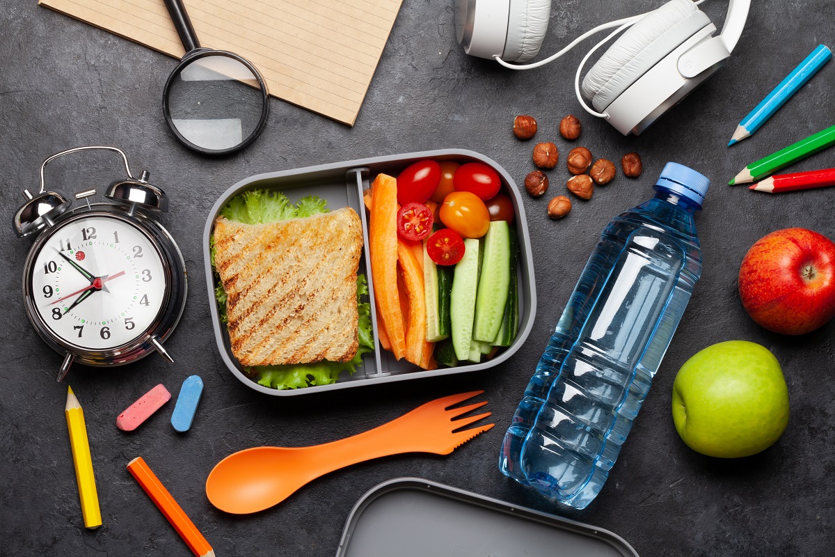 school lunch box and education stationery on stone table