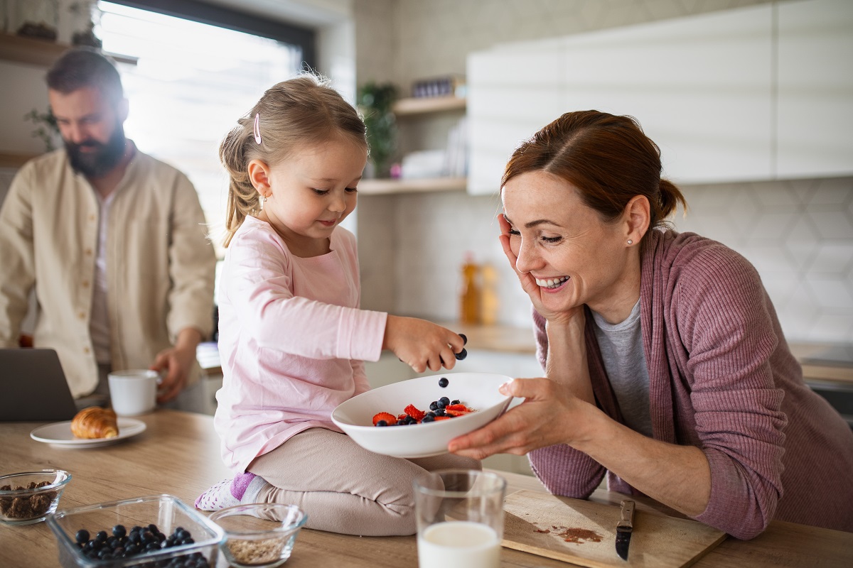 family with small daughter indoors in kitchen at home, everyday life and home office with child concept.